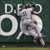 Funny pic of a baseball player smashing into another outfielder against the wall.jpg